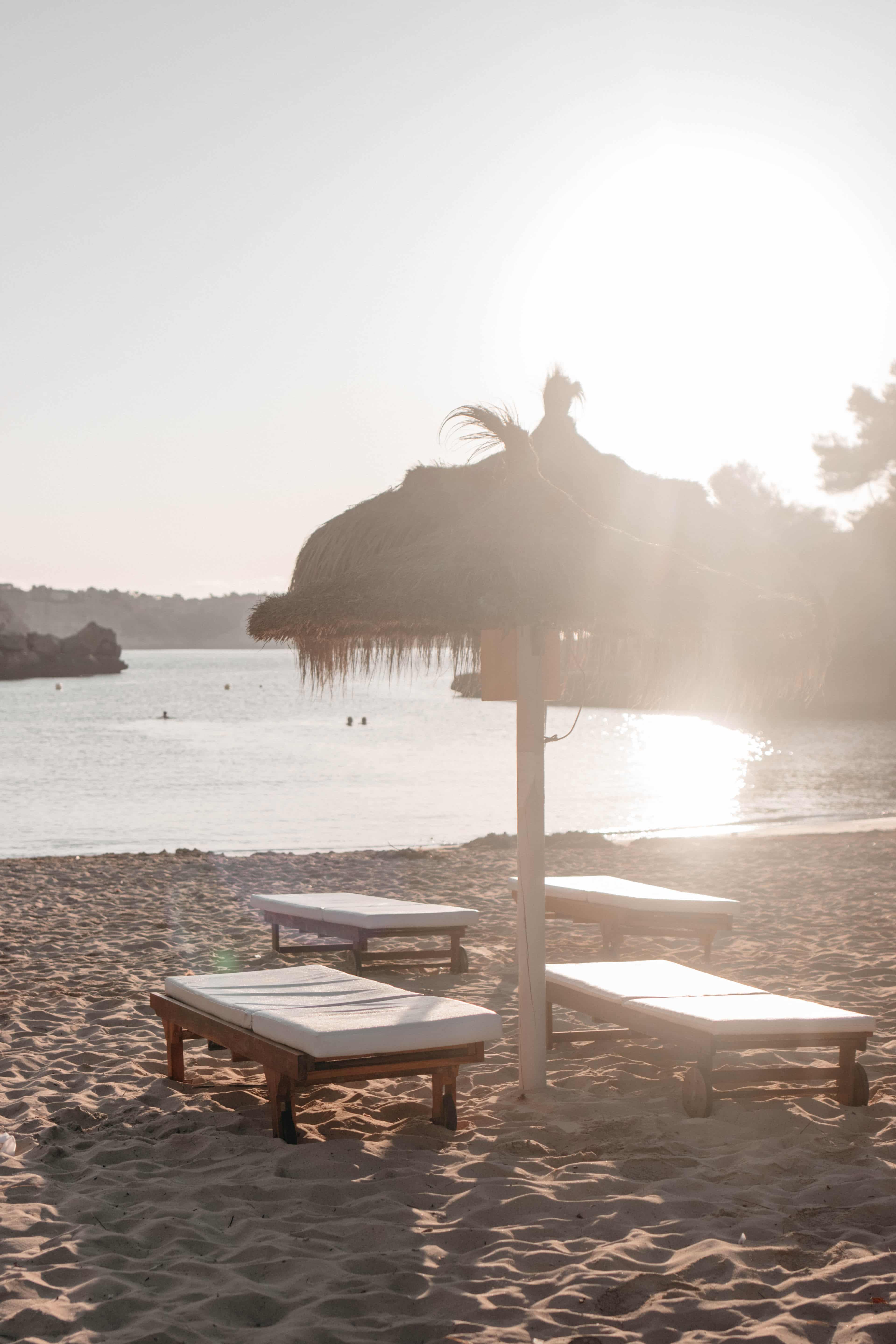 liege mit sonnenschirm cala llombards früh morgens 