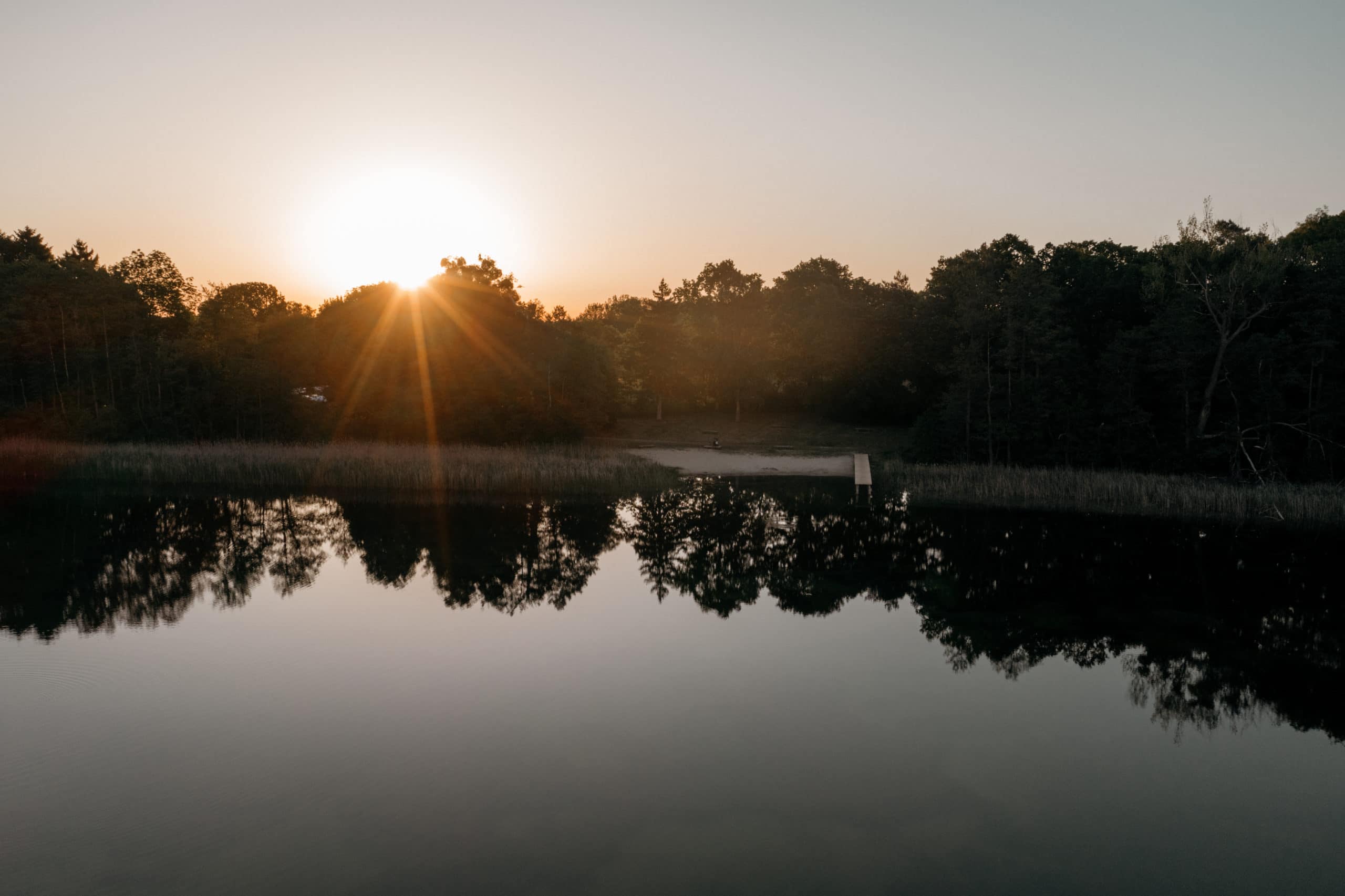 sonnunaufgang über see mit steg